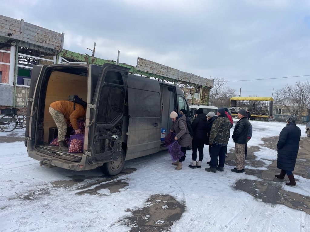Загальний план зимової видачі овочів біля відкритого мікроавтобуса