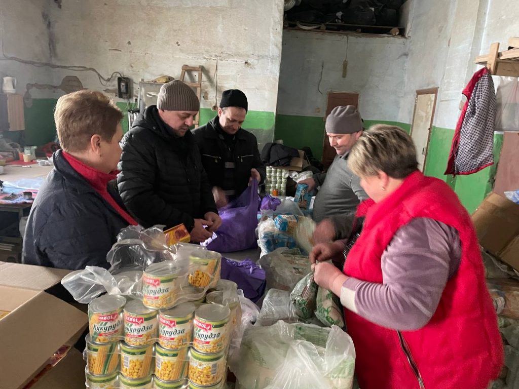 Команда пакує продуктові набори за столом на складі