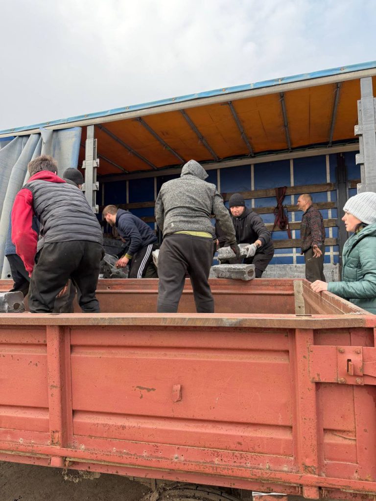 Паливні брикети перевантажують із вантажівки до відкритого причепа