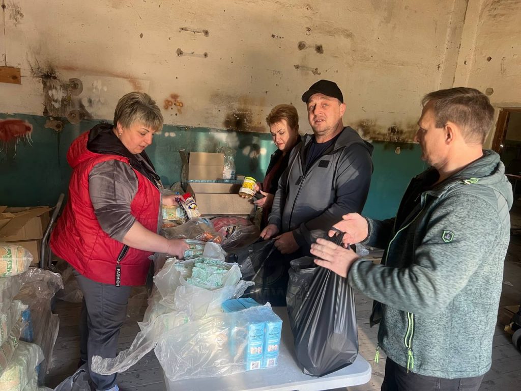 Команда разом фасує продукти у пакети за столом