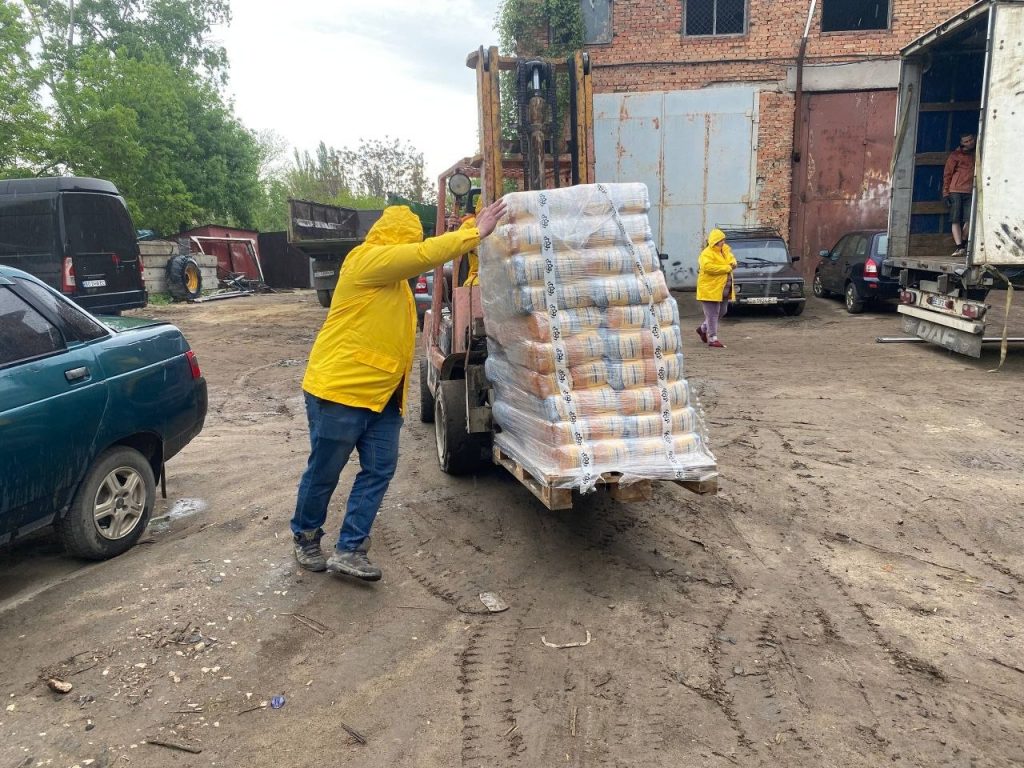 Працівник спрямовує палету з продуктами під час розвантаження
