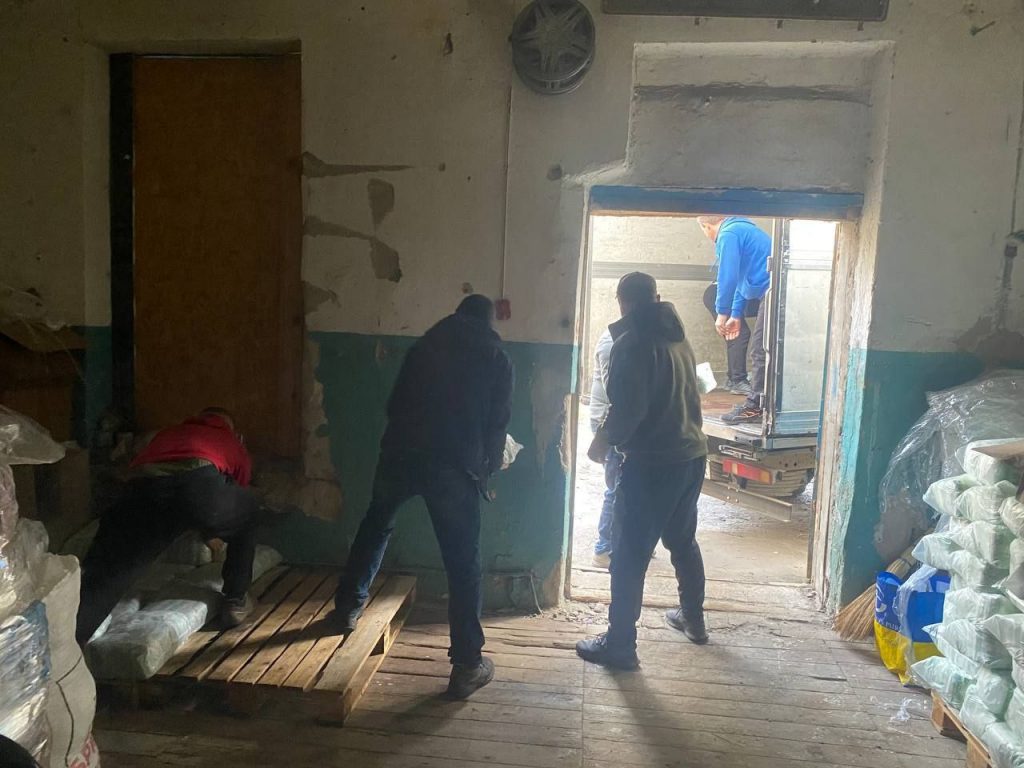 Працівники розвантажують продукти через двері до приміщення складу