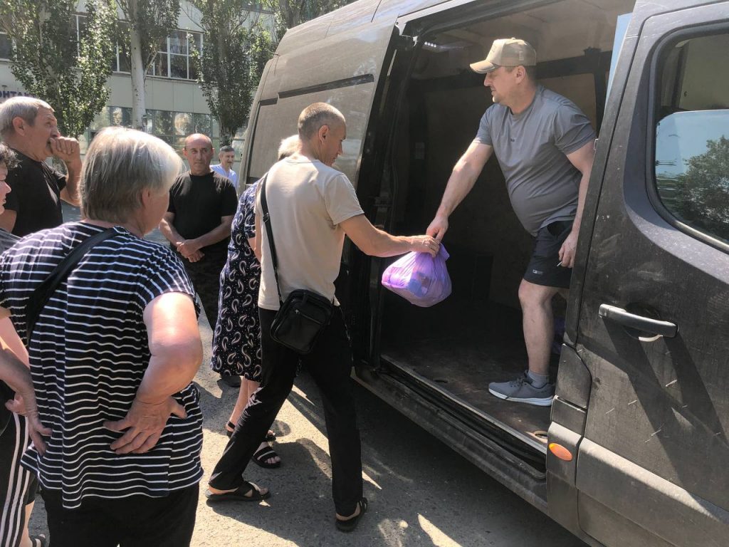 Команда видає продуктові набори з мікроавтобуса